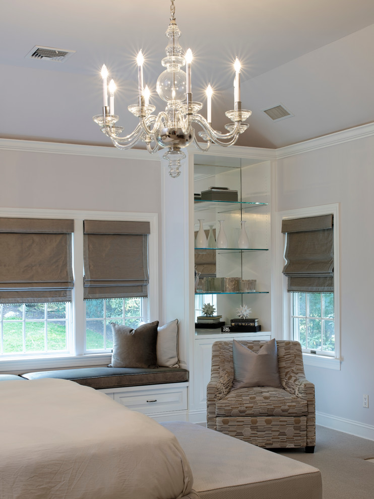 This is an example of a large traditional master bedroom in New York with white walls, carpet and no fireplace.