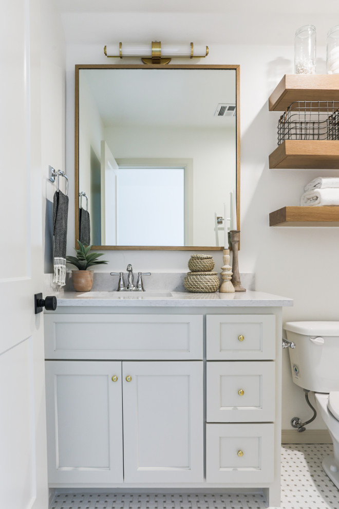 This is an example of a mid-sized traditional 3/4 bathroom in Oklahoma City with shaker cabinets, beige cabinets, an alcove tub, a shower/bathtub combo, a one-piece toilet, white tile, porcelain tile, white walls, mosaic tile floors, an undermount sink, engineered quartz benchtops, white floor, a shower curtain, white benchtops, a single vanity and a built-in vanity.