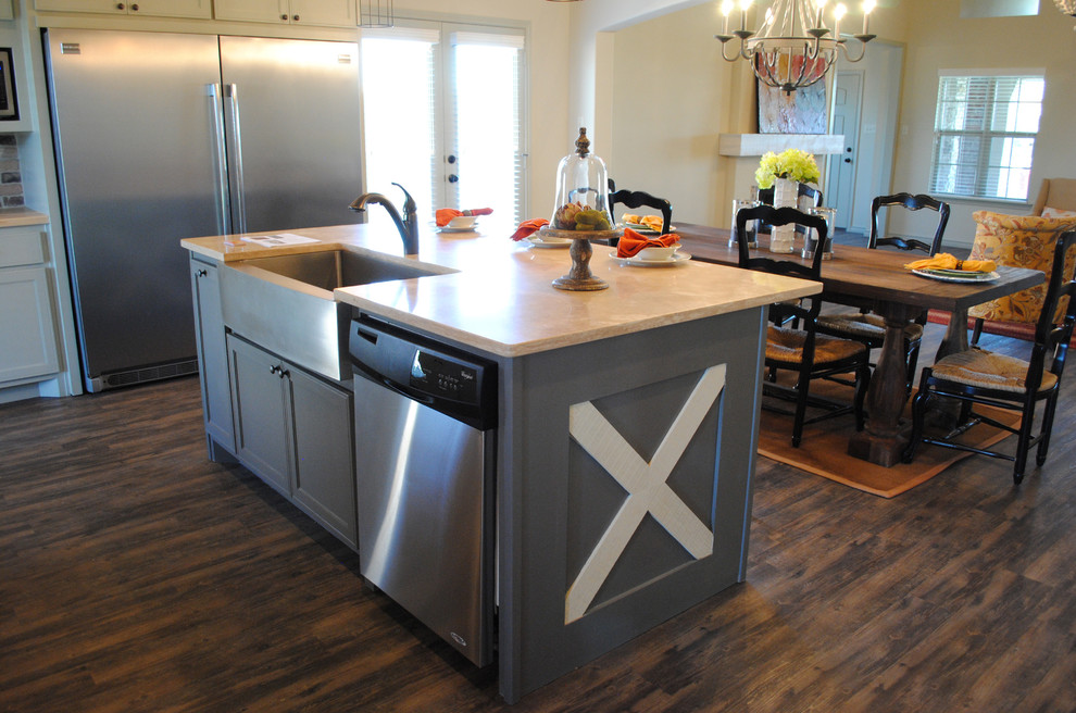 This is an example of a mediterranean eat-in kitchen in Austin with a farmhouse sink, wood benchtops, stainless steel appliances, vinyl floors and with island.