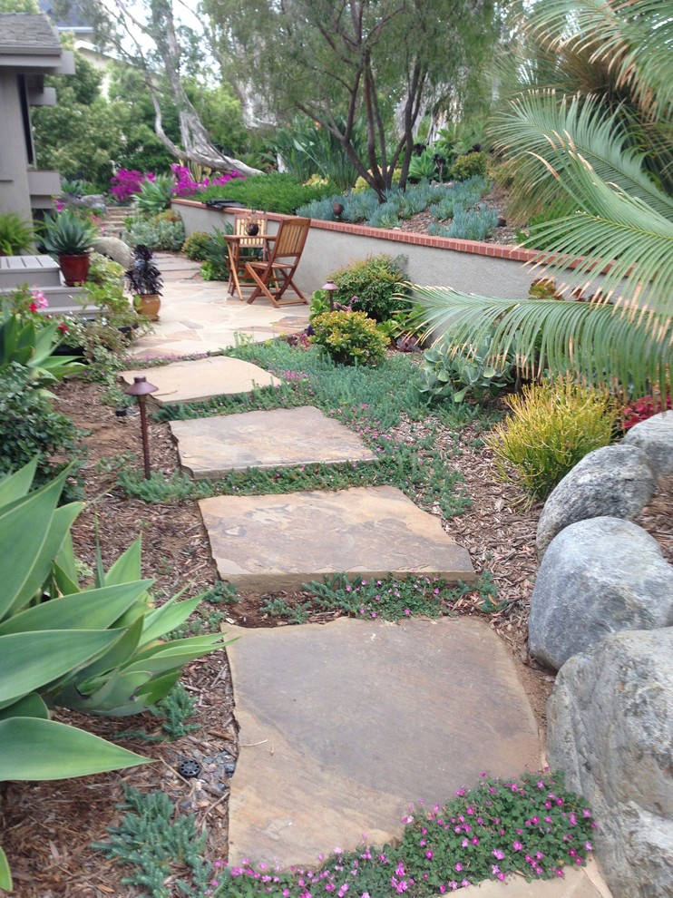 Small eclectic side yard garden in San Diego with natural stone pavers.