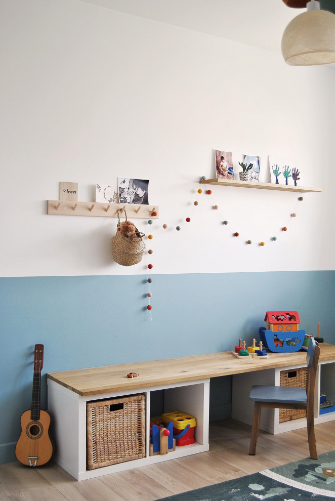 Réalisation d'une chambre d'enfant nordique de taille moyenne avec un mur blanc, sol en stratifié et du papier peint.