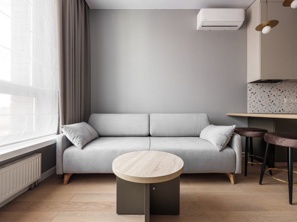 Стильный дизайн: открытая гостиная комната среднего размера в скандинавском стиле с серыми стенами, полом из ламината и бежевым полом - последний тренд