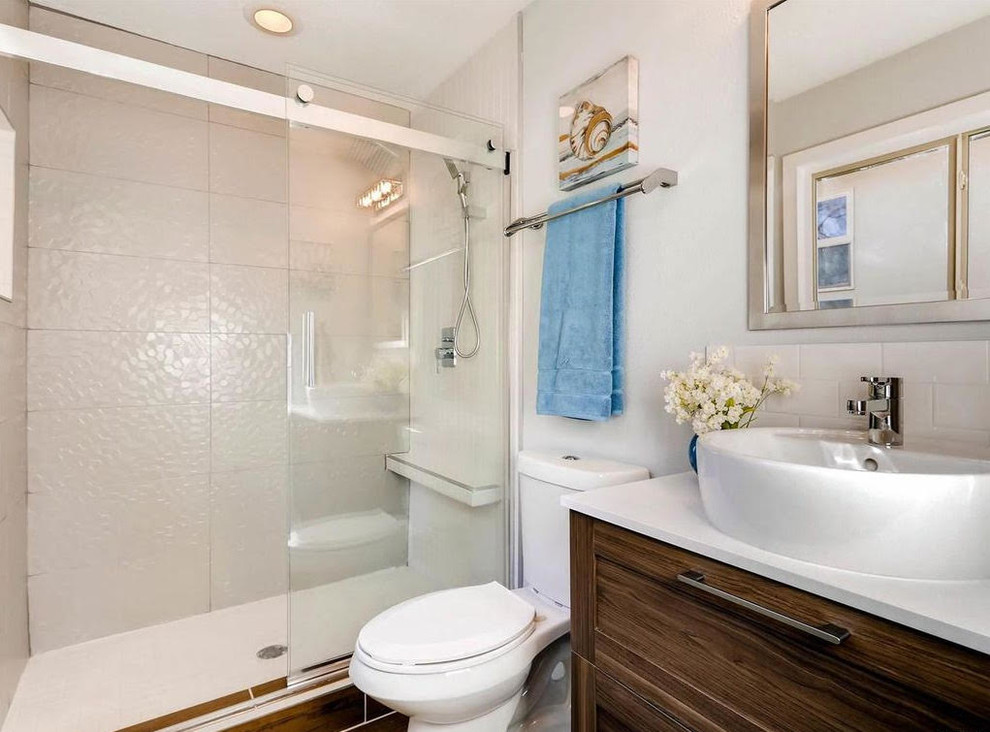 Example of a mid-sized transitional 3/4 ceramic tile and beige tile alcove bathtub design with white cabinets, white walls, shaker cabinets, a two-piece toilet, a vessel sink and quartz countertops