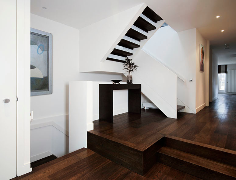 Large contemporary wood l-shaped staircase in London with open risers.