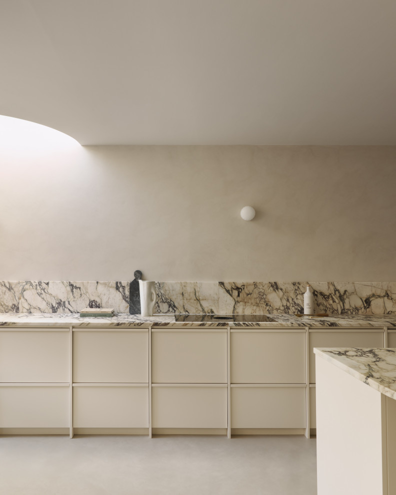 Photo of a large scandi single-wall kitchen/diner in London with recessed-panel cabinets, beige cabinets, marble worktops, marble splashback, integrated appliances, concrete flooring, an island and a feature wall.
