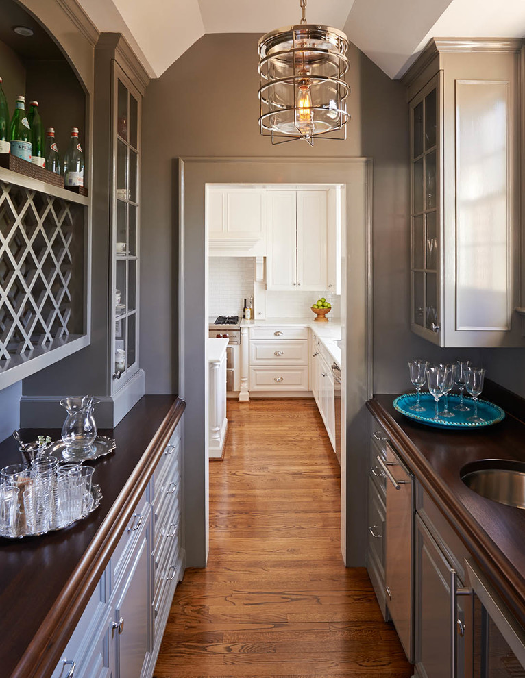 Design ideas for a mid-sized traditional galley kitchen pantry in Charlotte with raised-panel cabinets, grey cabinets, wood benchtops and medium hardwood floors.