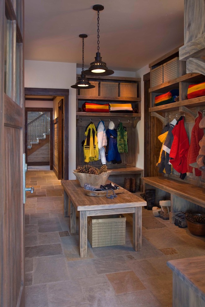 Photo of a large country mudroom in New York with white walls, slate floors, a single front door, a medium wood front door and brown floor.