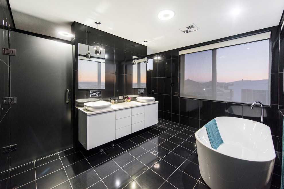 Design ideas for a contemporary master bathroom in Perth with a freestanding tub, an open shower, black tile, black walls and black floor.