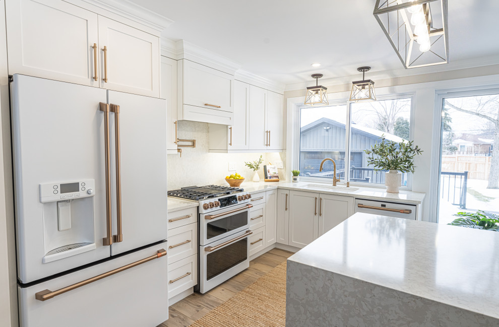 Inspiration for a large contemporary l-shaped kitchen/diner in Ottawa with a submerged sink, shaker cabinets, white cabinets, engineered stone countertops, beige splashback, engineered quartz splashback, white appliances, vinyl flooring, an island, beige floors and beige worktops.