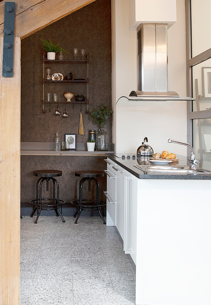 Inspiration for a small industrial u-shaped open plan kitchen in Other with a double-bowl sink, flat-panel cabinets, white cabinets, solid surface benchtops, brown splashback, stone slab splashback, stainless steel appliances, terrazzo floors, with island, grey floor and brown benchtop.