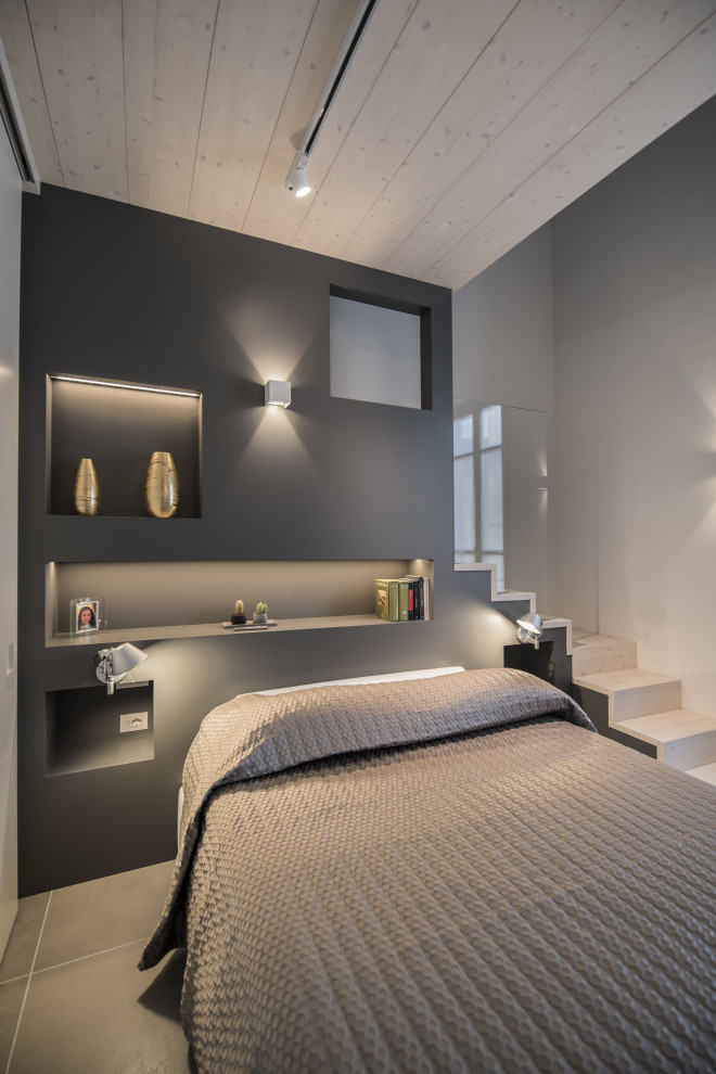 This is an example of a mid-sized modern bedroom in Florence with white walls, porcelain floors, grey floor, wood and panelled walls.