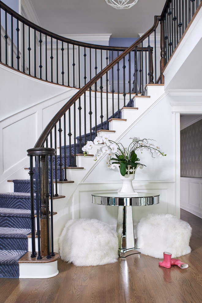 This is an example of a transitional wood curved staircase in New York with painted wood risers and mixed railing.