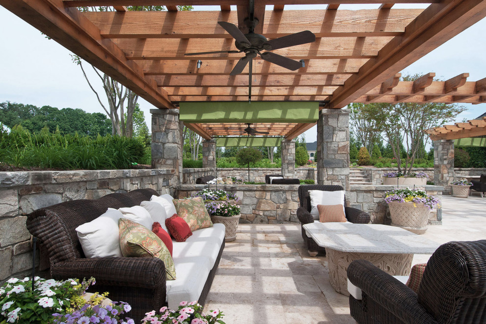 Inspiration for an expansive traditional backyard patio in DC Metro with an outdoor kitchen, natural stone pavers and a pergola.