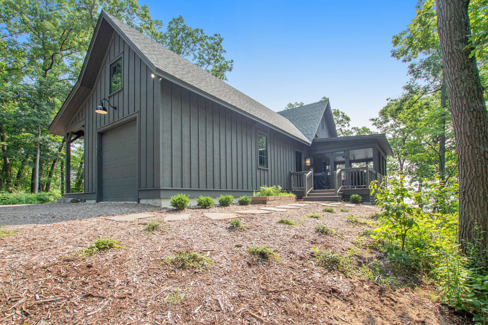 Black rustic detached house in Grand Rapids with wood cladding, a pitched roof, a shingle roof and board and batten cladding.