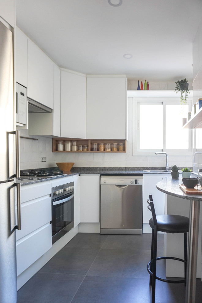 Idéer för avskilda, mellanstora funkis svart l-kök, med en dubbel diskho, släta luckor, vita skåp, marmorbänkskiva, vitt stänkskydd, stänkskydd i keramik, rostfria vitvaror, klinkergolv i porslin, en halv köksö och svart golv