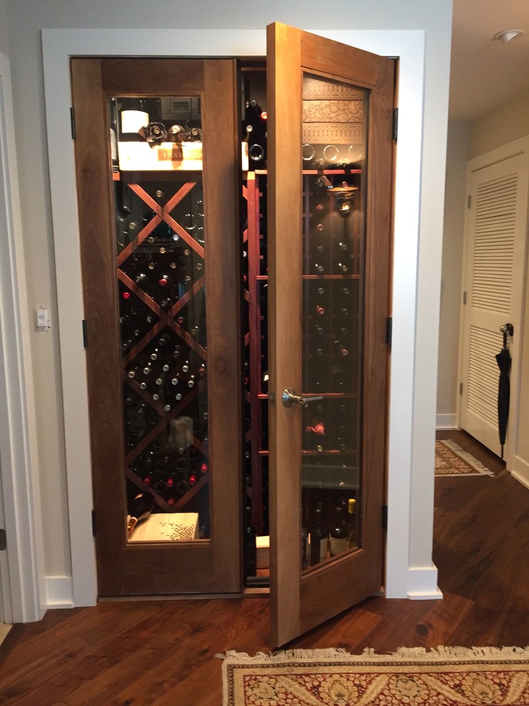 Photo of a small traditional wine cellar in Tampa with medium hardwood floors, diamond bins and brown floor.
