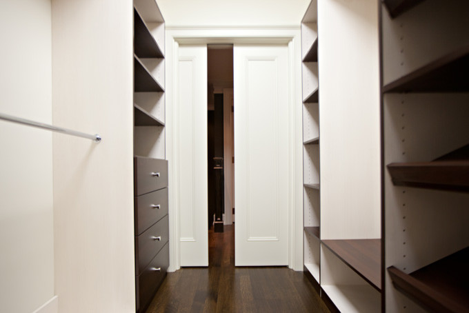 Imagen de armario vestidor unisex moderno grande con armarios con paneles lisos, puertas de armario de madera en tonos medios, suelo de madera oscura y suelo marrón