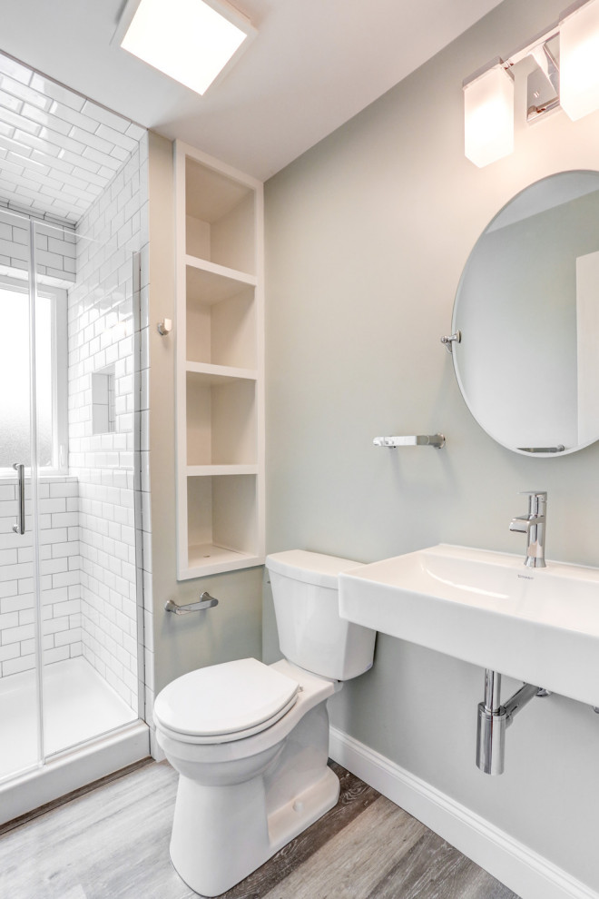 Inredning av ett modernt litet en-suite badrum, med en dusch i en alkov, en toalettstol med separat cisternkåpa, vit kakel, keramikplattor, grå väggar, vinylgolv, ett piedestal handfat, grått golv och dusch med gångjärnsdörr