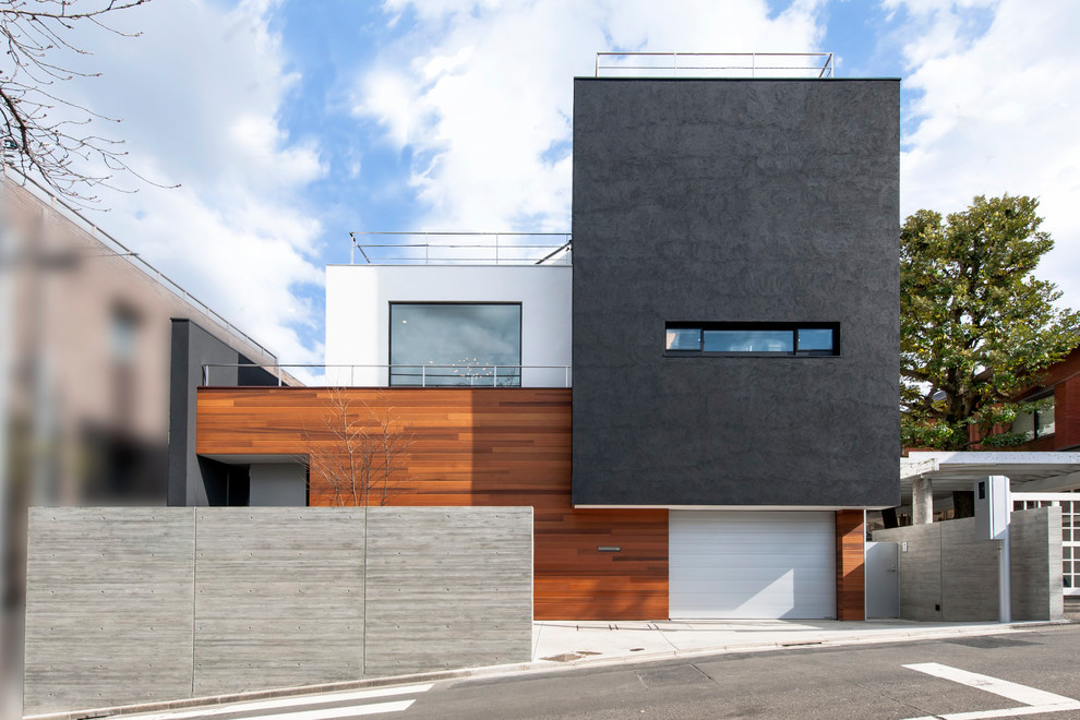 Contemporary three-storey multi-coloured house exterior in Tokyo with mixed siding and a flat roof.