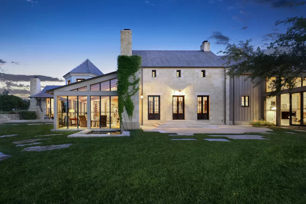 This is an example of a beige rustic two floor detached house in Austin with stone cladding.