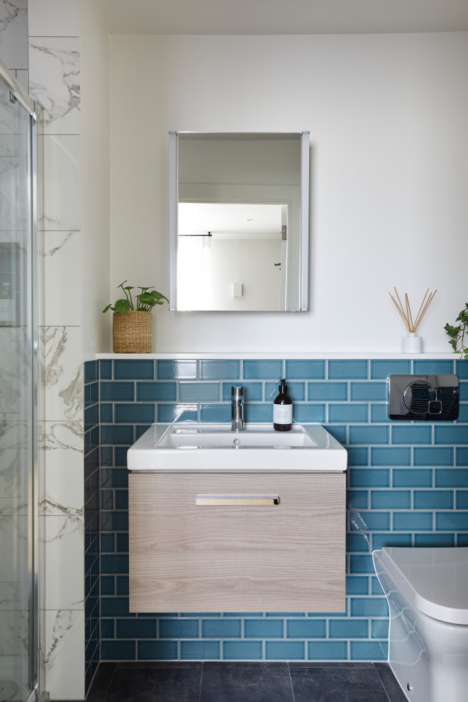 На фото: маленькая главная ванная комната в стиле неоклассика (современная классика) с плоскими фасадами, светлыми деревянными фасадами, открытым душем, унитазом-моноблоком, синей плиткой, керамической плиткой, синими стенами, полом из керамической плитки, накладной раковиной, столешницей из кварцита, серым полом, душем с раздвижными дверями, белой столешницей, нишей, тумбой под одну раковину и подвесной тумбой для на участке и в саду с