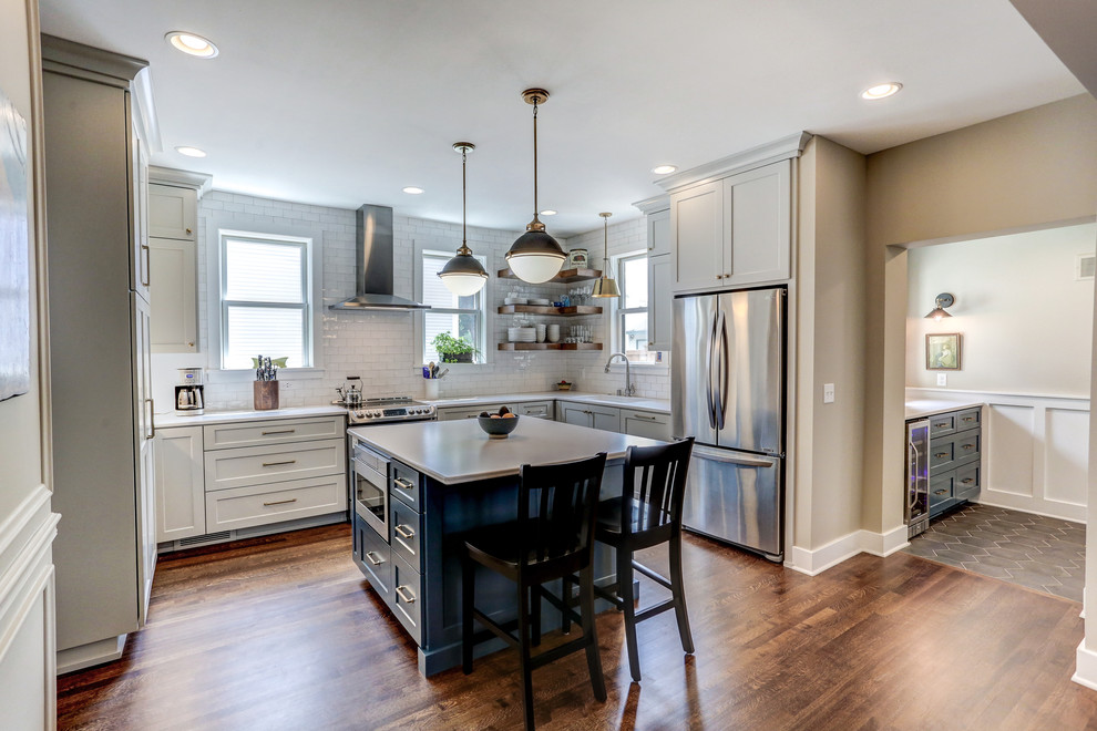 Inspiration for a mid-sized transitional u-shaped eat-in kitchen in Minneapolis with an undermount sink, white cabinets, quartz benchtops, white splashback, subway tile splashback, stainless steel appliances, vinyl floors, with island, brown floor, white benchtop and shaker cabinets.
