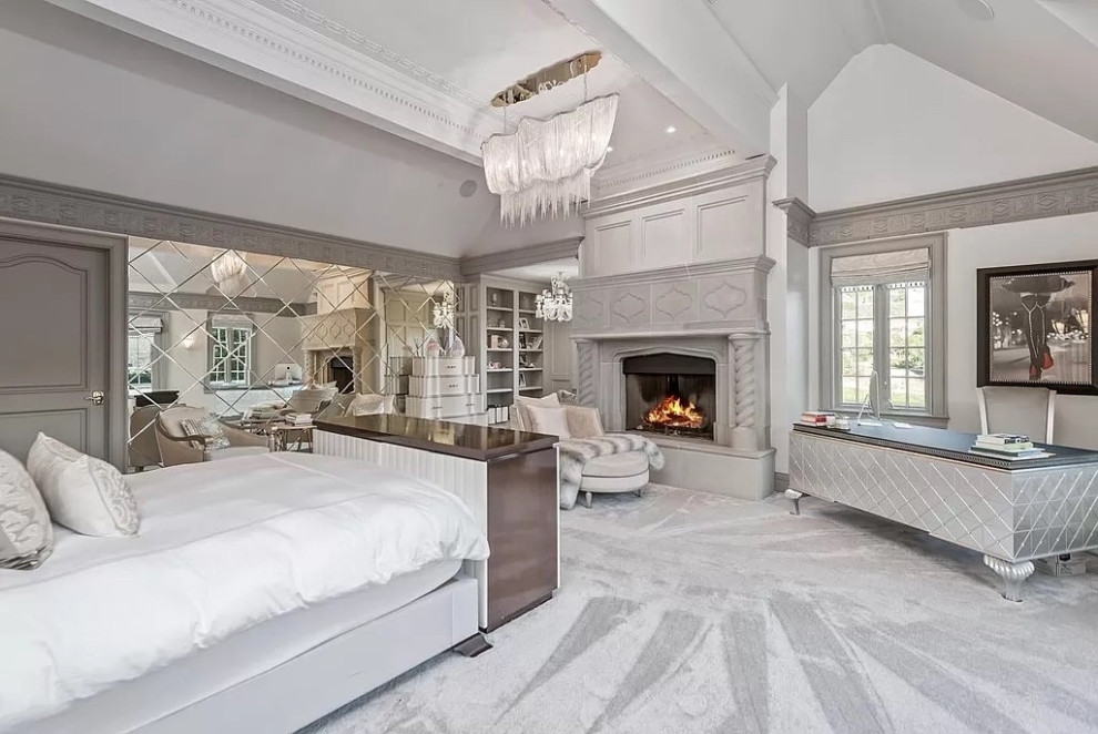 Inspiration for a mid-sized master vaulted ceiling, carpeted and gray floor bedroom remodel in Los Angeles with a standard fireplace, a stone fireplace and white walls
