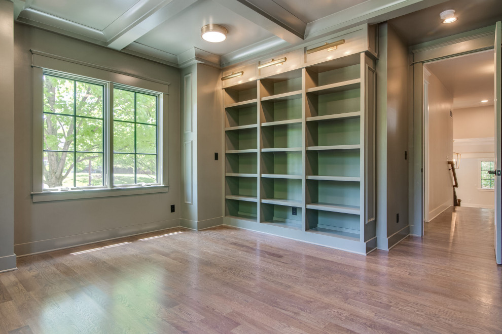 Large transitional study room in Nashville with green walls, medium hardwood floors, brown floor, coffered and panelled walls.