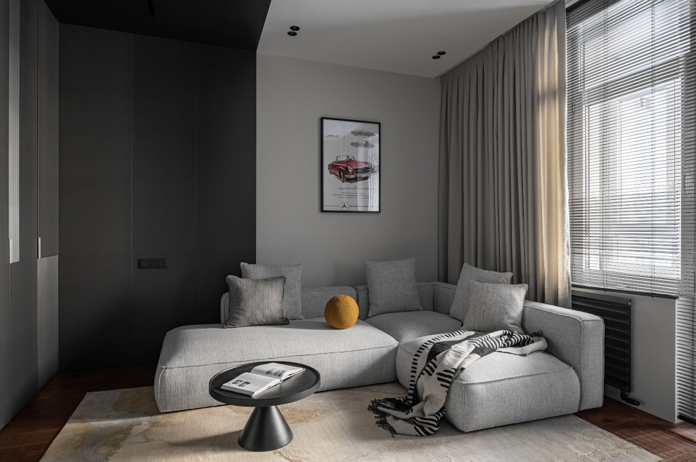 Пример оригинального дизайна: серо-белая гостиная комната среднего размера в современном стиле с черными стенами, паркетным полом среднего тона, телевизором на стене, зоной отдыха и ковром на полу