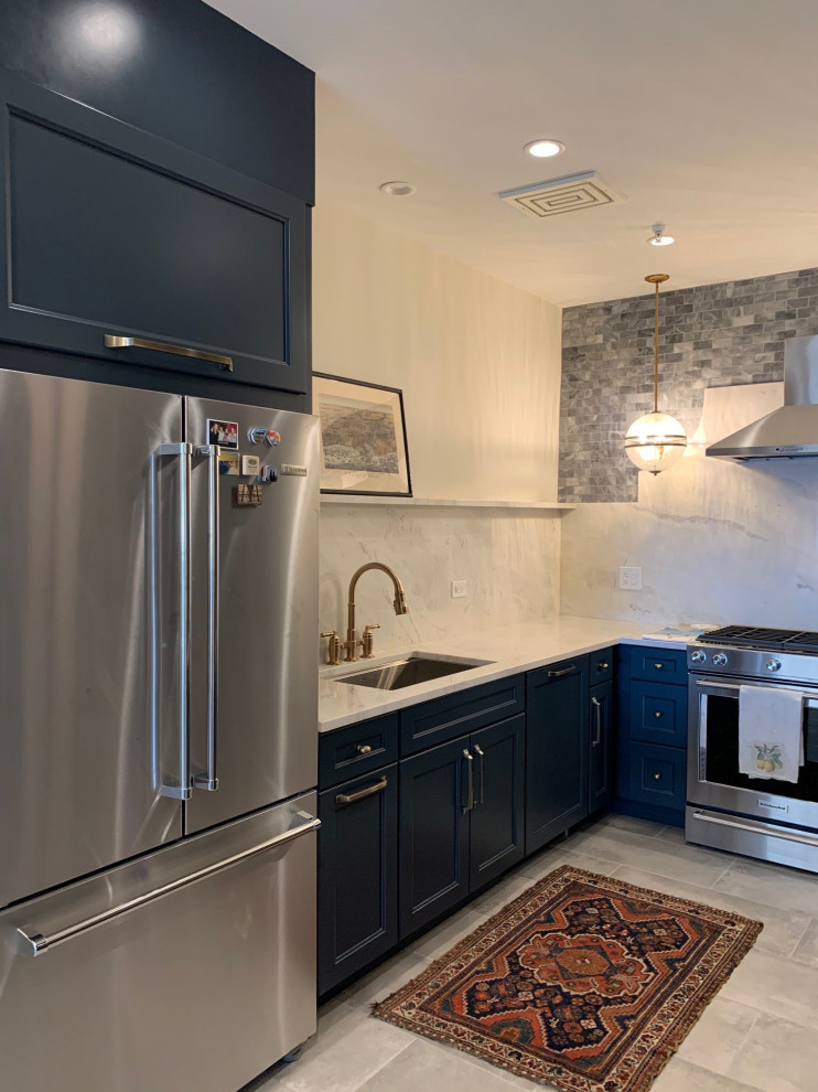 Photo of a small eclectic u-shaped separate kitchen in Chicago with an undermount sink, shaker cabinets, blue cabinets, quartz benchtops, white splashback, engineered quartz splashback, stainless steel appliances, grey floor and white benchtop.