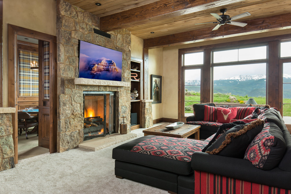 Photo of a country family room in Denver with carpet, a standard fireplace, a stone fireplace surround and a wall-mounted tv.