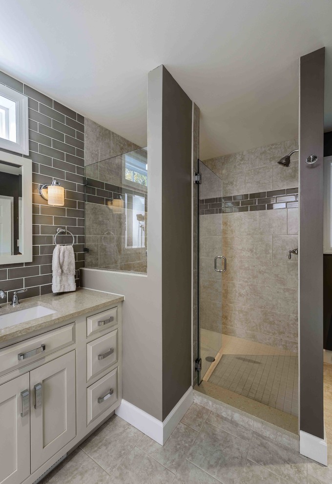 Inspiration for a mid-sized traditional master bathroom in Other with raised-panel cabinets, beige cabinets, an alcove shower, a two-piece toilet, beige tile, subway tile, grey walls, ceramic floors, an undermount sink, engineered quartz benchtops and beige floor.