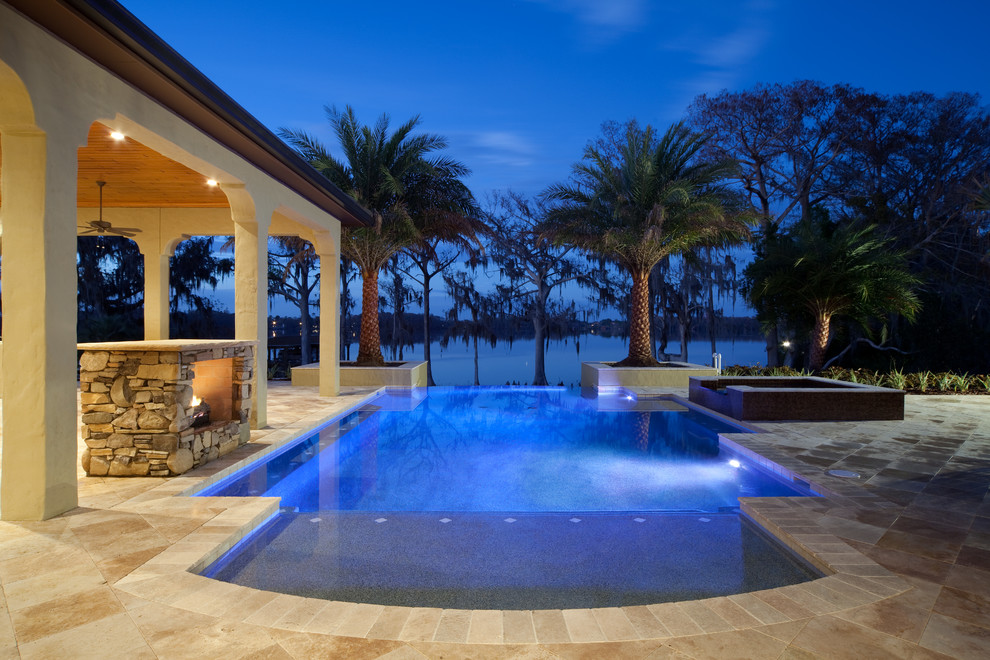 This is an example of a transitional pool in Orlando with natural stone pavers.