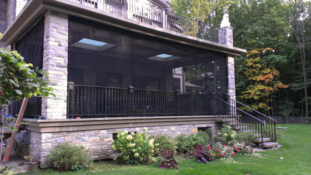 Inspiration for a large contemporary backyard screened-in verandah in Toronto with decking and a roof extension.