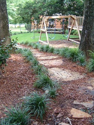 Design ideas for a mid-sized traditional backyard partial sun garden in Atlanta with with outdoor playset and natural stone pavers.