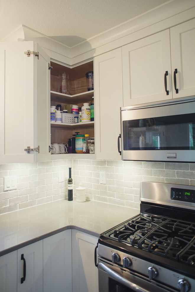 Eat-in kitchen - mid-sized transitional l-shaped eat-in kitchen idea in Vancouver with shaker cabinets, white cabinets, quartz countertops, gray backsplash, stainless steel appliances, an island, porcelain backsplash and white countertops