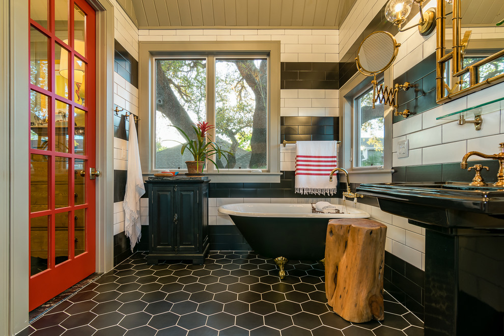 Traditional master bathroom in Austin with a claw-foot tub, black tile, black and white tile, white tile, subway tile, multi-coloured walls, a pedestal sink and black floor.