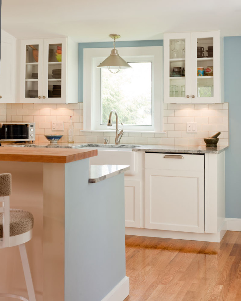 Design ideas for a traditional kitchen in Boston with glass-front cabinets, subway tile splashback and a farmhouse sink.