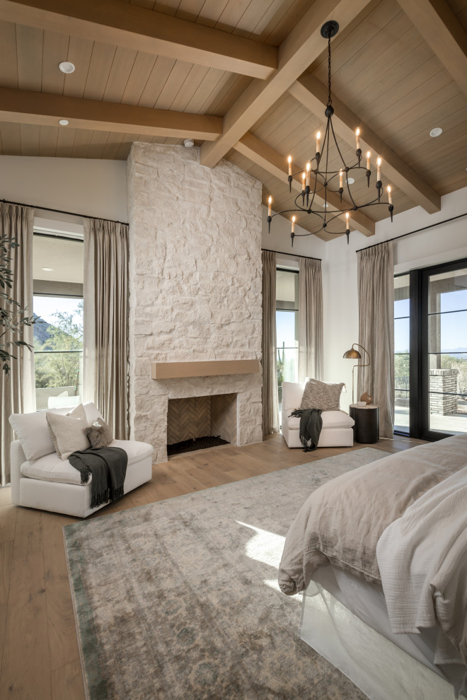 フェニックスにある広いトランジショナルスタイルのおしゃれな主寝室 (白い壁、淡色無垢フローリング、標準型暖炉、石材の暖炉まわり、ベージュの床、板張り天井、板張り壁) のレイアウト