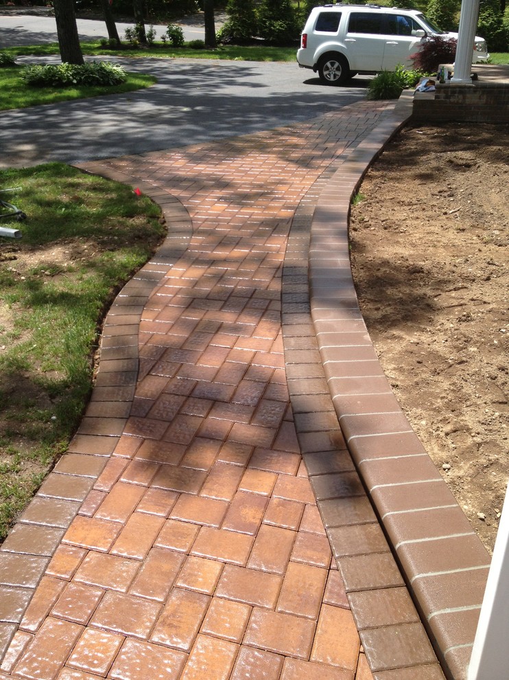 Inspiration for a contemporary front yard driveway in New York with a garden path and concrete pavers.