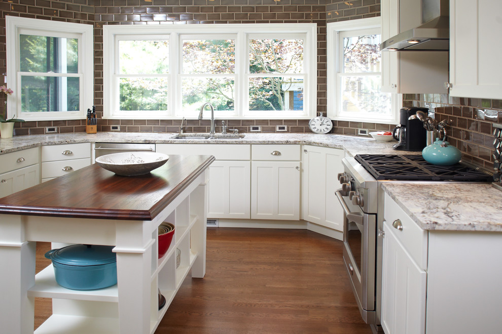 Design ideas for a traditional u-shaped kitchen in Grand Rapids with brown splashback, subway tile splashback, an undermount sink, recessed-panel cabinets, white cabinets and stainless steel appliances.