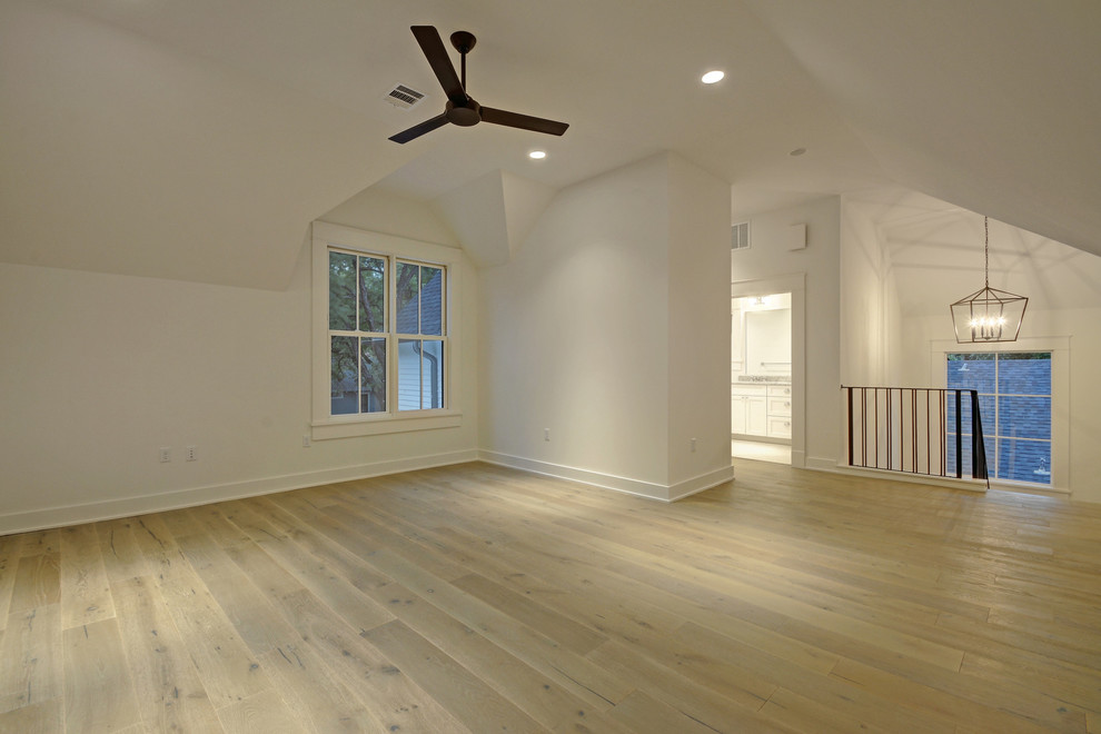 Photo of a mid-sized country loft-style family room in Austin with white walls, laminate floors and beige floor.