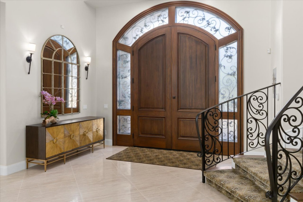 Ispirazione per un ampio ingresso stile marinaro con pareti bianche, pavimento in travertino, una porta a due ante, una porta in legno bruno e pavimento marrone
