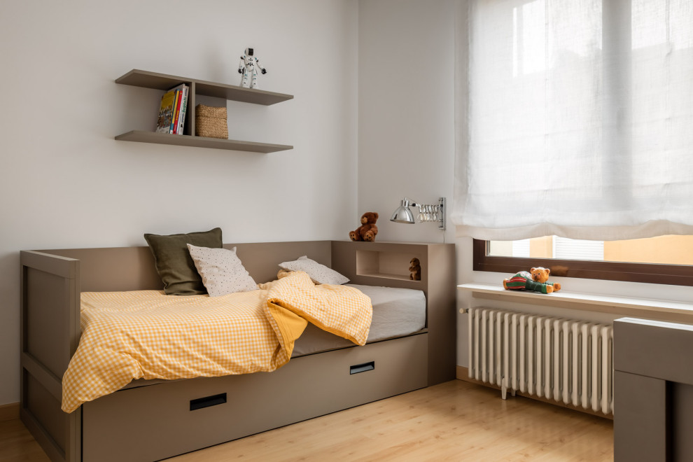 Medium sized classic gender neutral kids' bedroom in Barcelona with white walls and medium hardwood flooring.