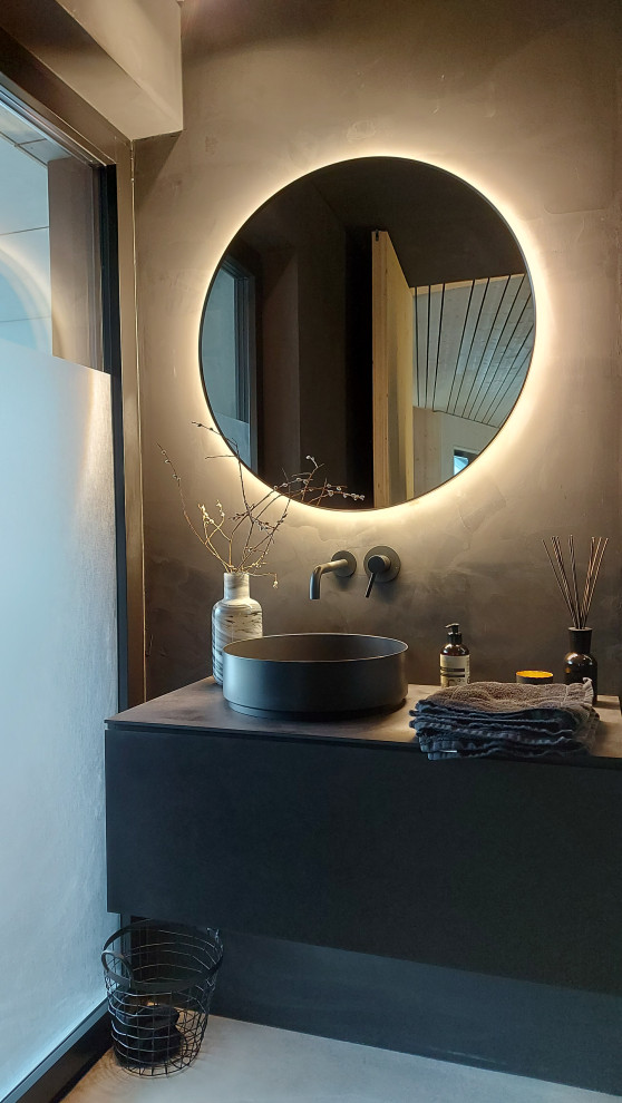 Cette image montre une très grande salle de bain grise et blanche avec des portes de placard noires, une douche à l'italienne, WC séparés, un mur gris, une vasque, aucune cabine, un plan de toilette noir, meuble simple vasque et meuble-lavabo suspendu.