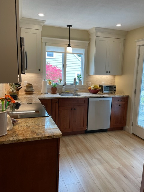 Inspiration for a large transitional l-shaped light wood floor and brown floor eat-in kitchen remodel in Boston with an undermount sink, shaker cabinets, white cabinets, granite countertops, white backsplash, stainless steel appliances, brown countertops and stone tile backsplash