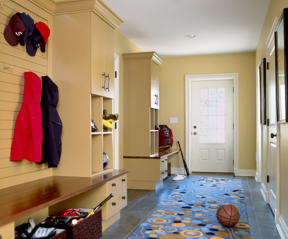 This is an example of a traditional mudroom in New York with yellow walls, a single front door and a glass front door.