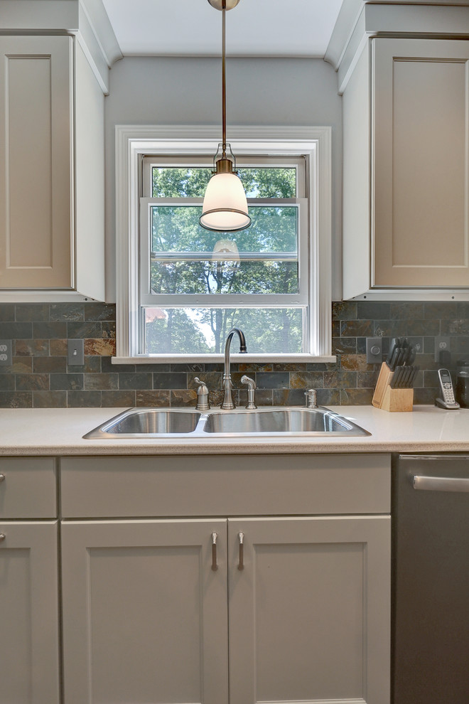 Example of a large eclectic u-shaped medium tone wood floor enclosed kitchen design with a drop-in sink, shaker cabinets, beige cabinets, quartz countertops, multicolored backsplash, stone tile backsplash, stainless steel appliances and no island