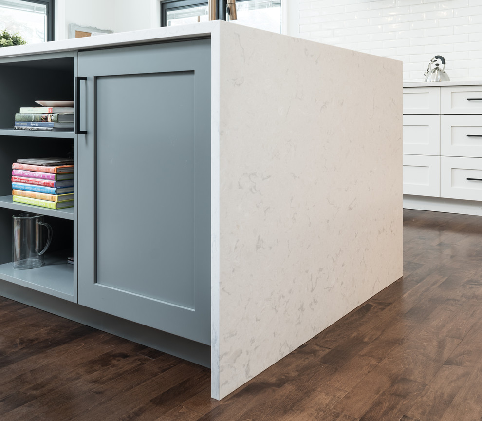 Huge transitional u-shaped medium tone wood floor and brown floor open concept kitchen photo in Toronto with an undermount sink, shaker cabinets, white cabinets, quartz countertops, white backsplash, subway tile backsplash, stainless steel appliances, an island and white countertops