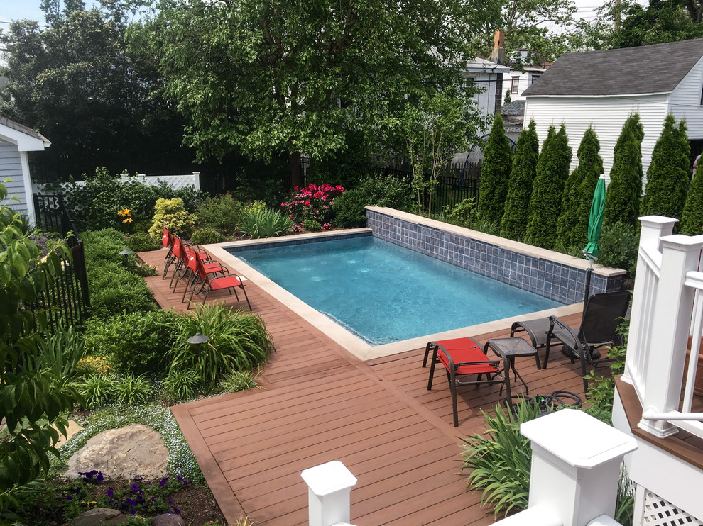 Mid-sized contemporary backyard rectangular pool in New York with decking.